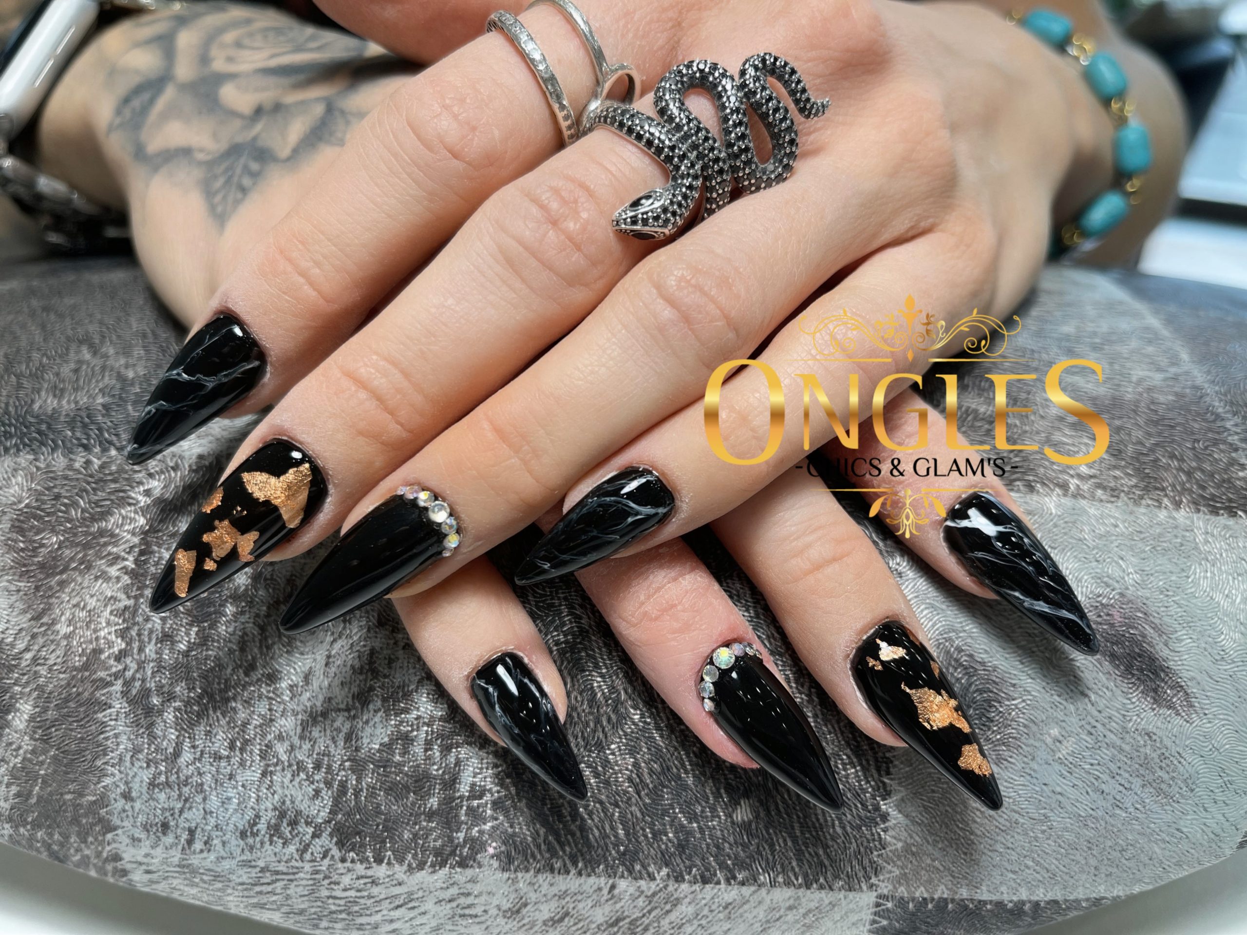 Pose d’ongles noirs avec détails dorés